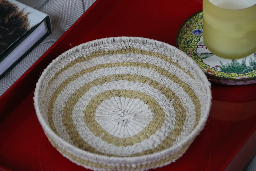 Colored chaguar basket on red tray with candle